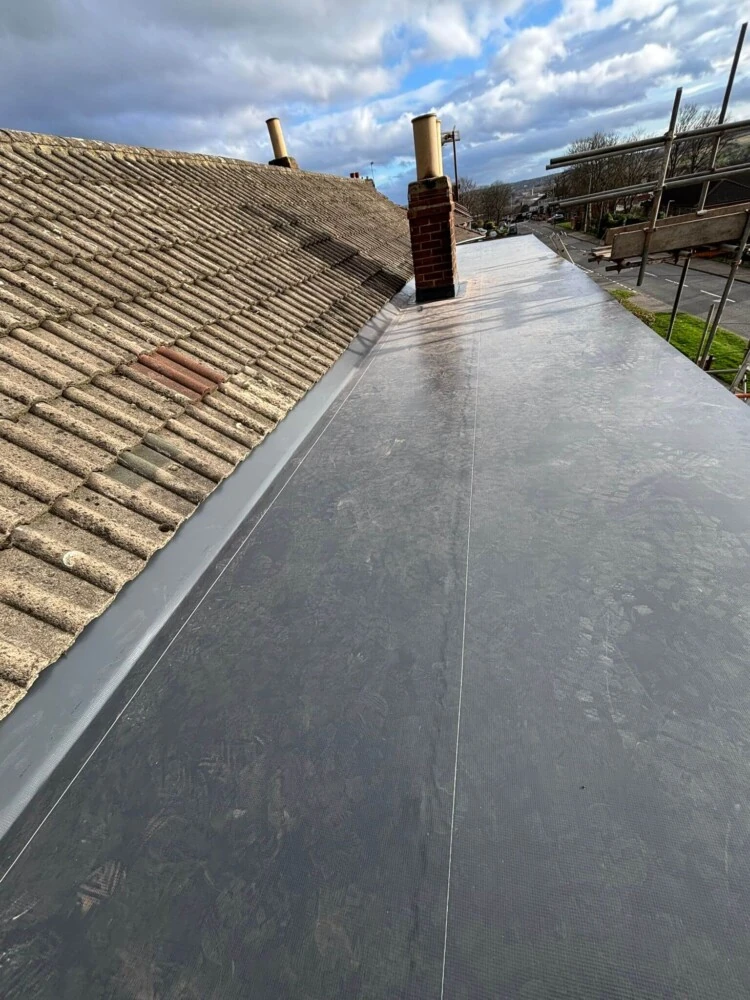 Completed flat roof alongside a slated pitched roof with chimney stack