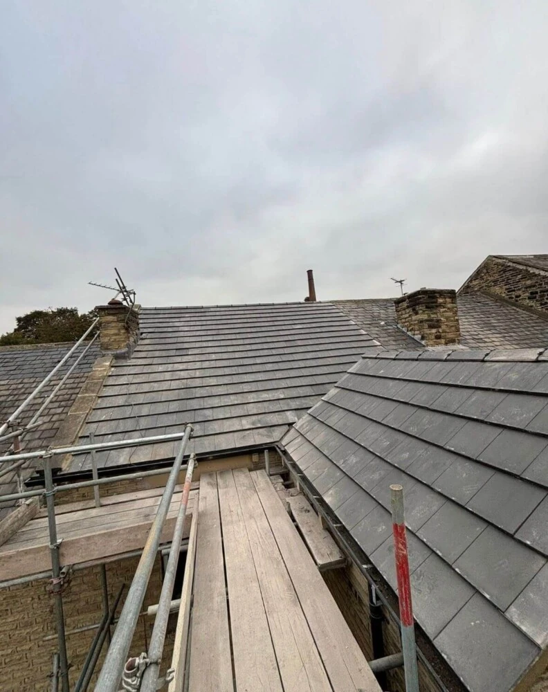 Slate roof edge with scaffolding and ladder access during repairs