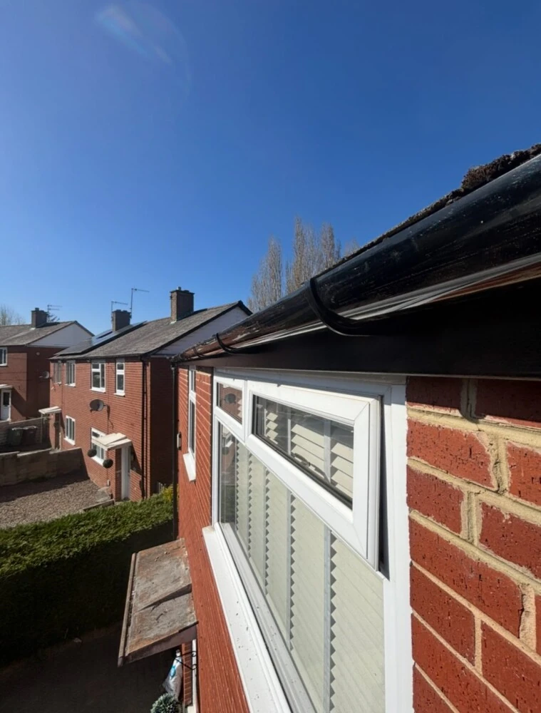 Terraced red brick houses with new roof edge fascia and guttering